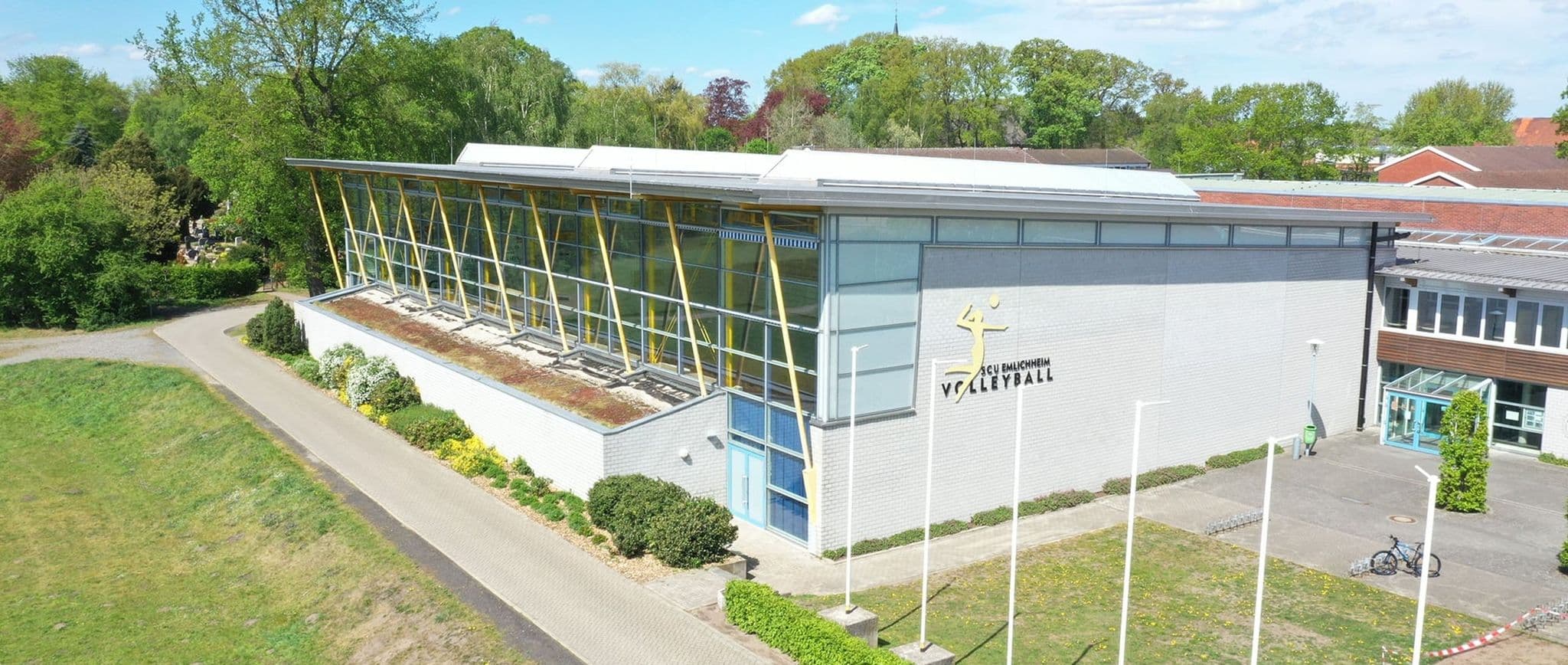 Die Vechtetalhalle in Emlichheim von außen, mit dem Volleyball-Schriftzug des SCU an der Fassade